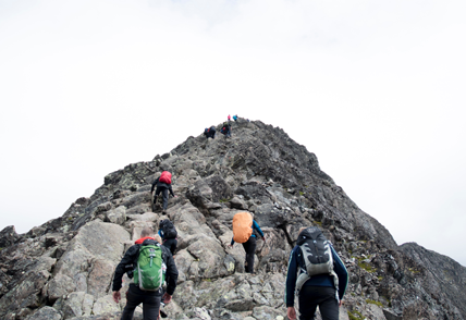 multiple climbers hiking up mountain